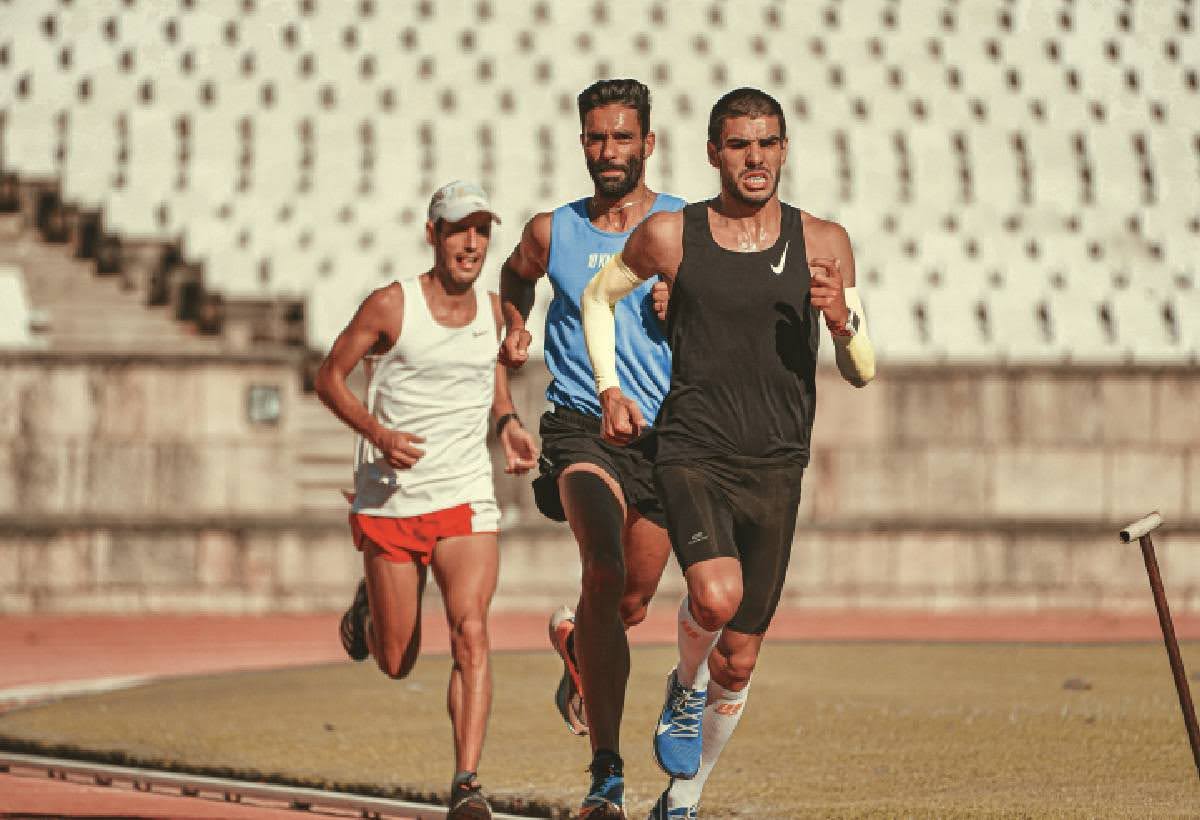 Competitive runners train intensely on a track, illustrating the benefits of infrared sauna in enhancing athletic recovery and performance