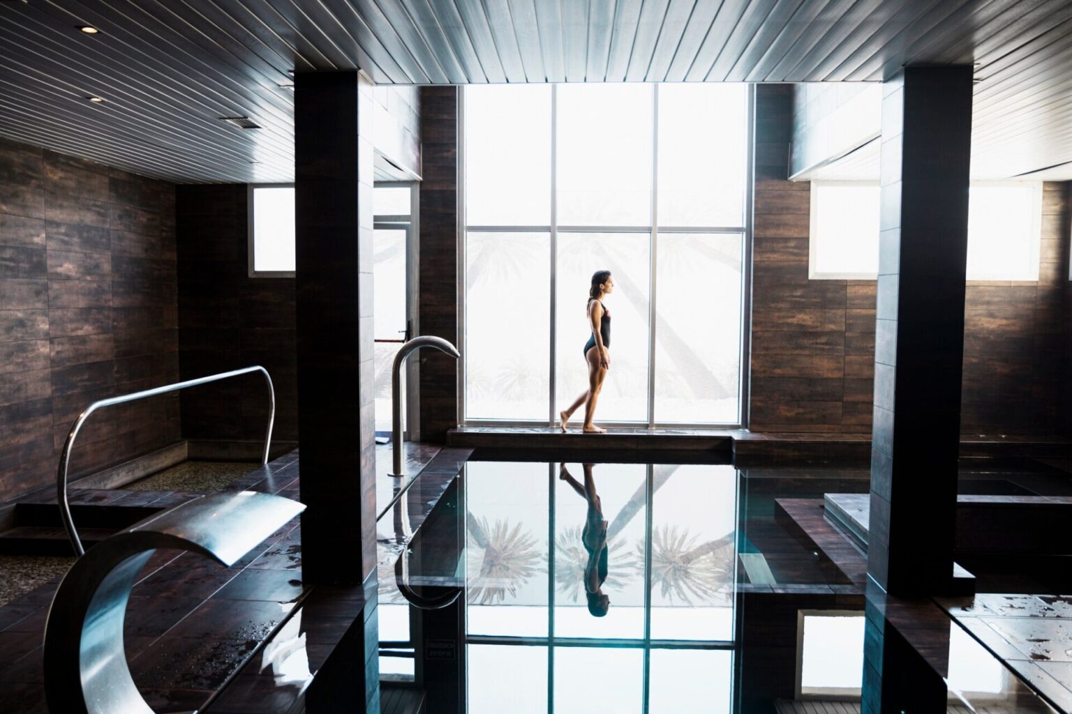 Woman enjoying both infrared sauna and swimming pool for wellness